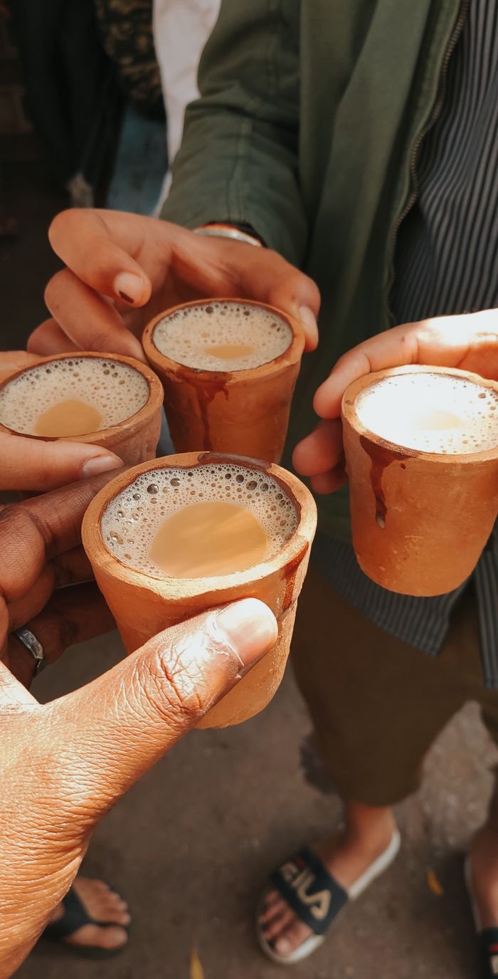 services-04 Friends toasting with traditional masala chai in clay cups, capturing a vibrant cultural moment.